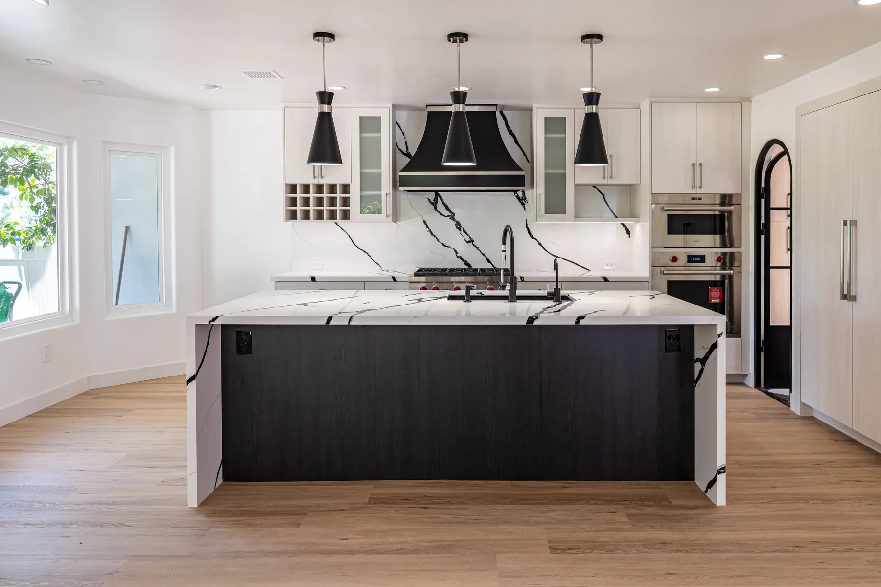 Full custom kitchen with white oak cabinetry, a large island, and full-height stone