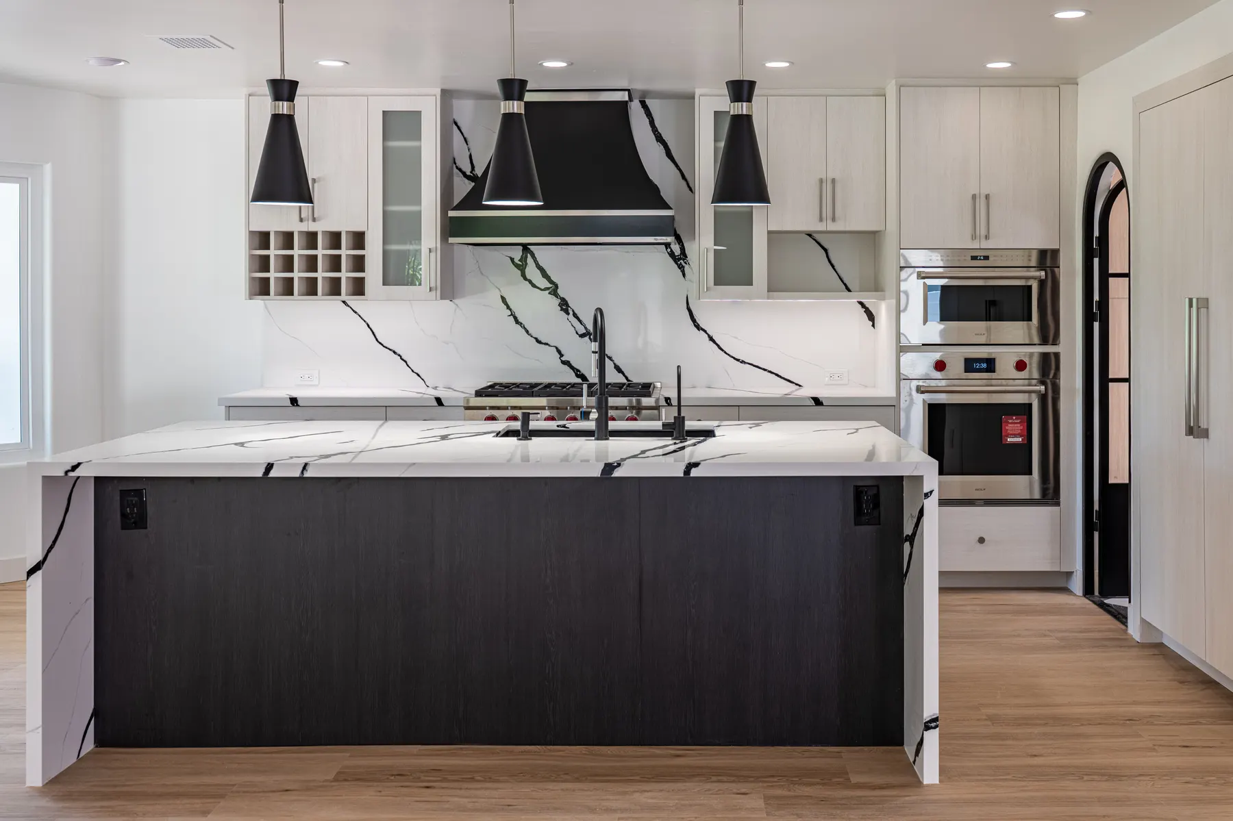 Custom Black Hills Oak island cabinetry with a waterfall quartz countertop