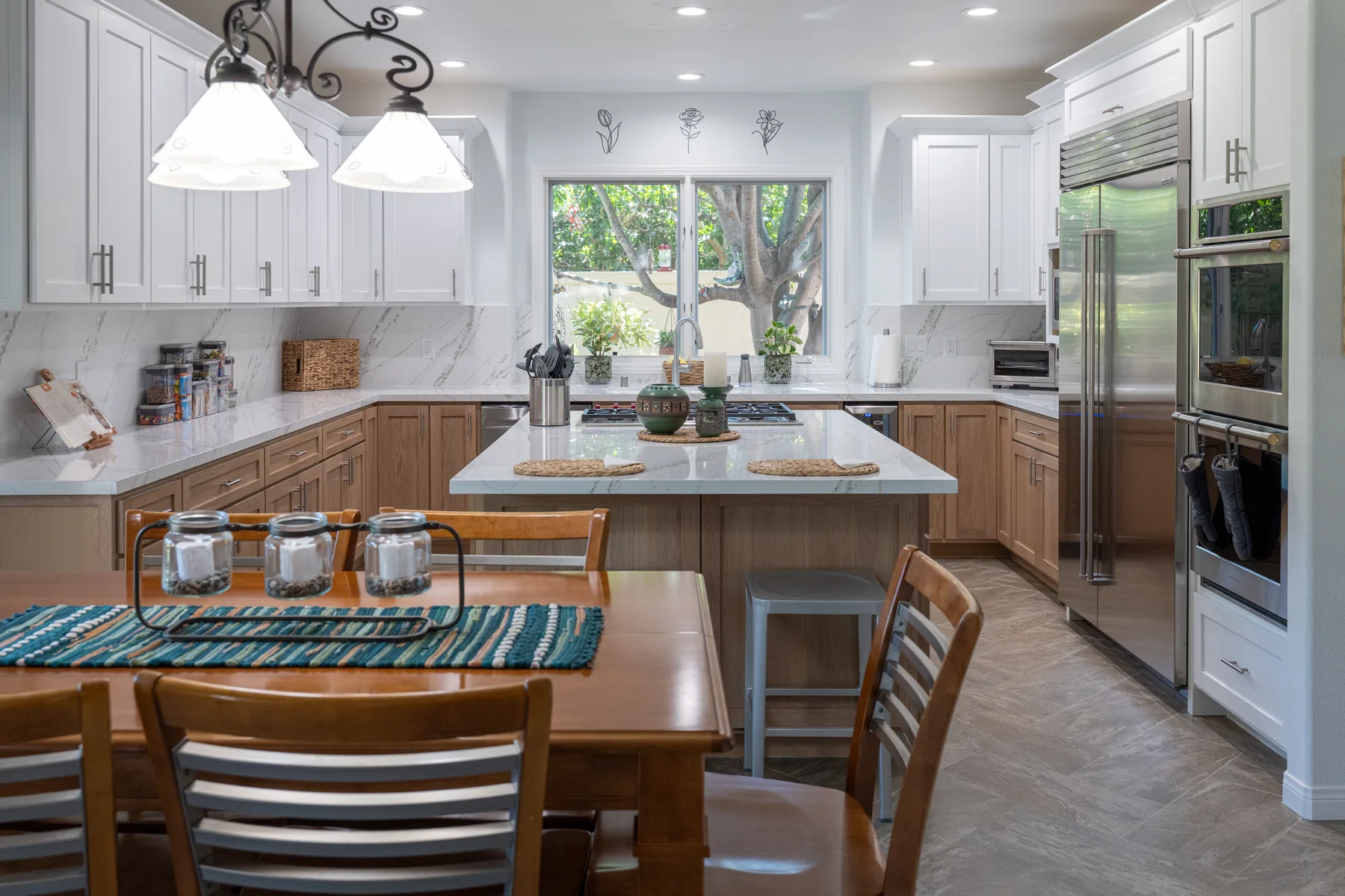 Full custom white and oak kitchen with a large quartz island and integrated cabinetry