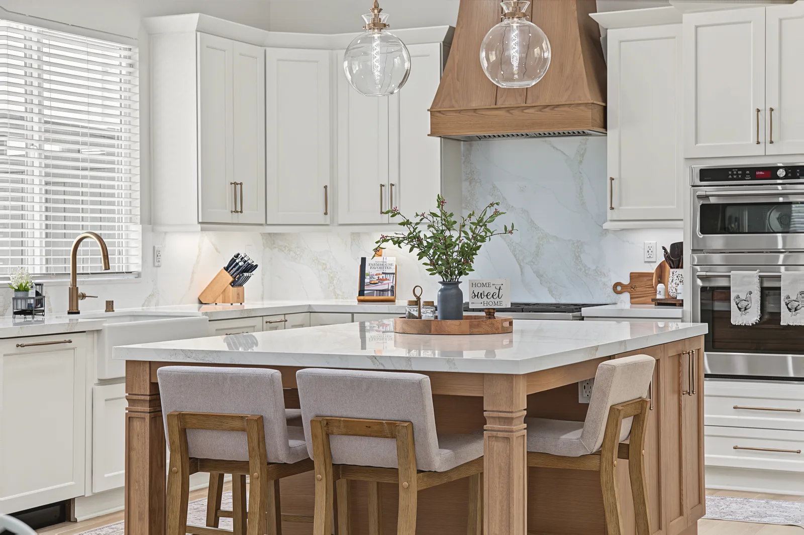 White oak kitchen with a waterfall island and veined stone countertops