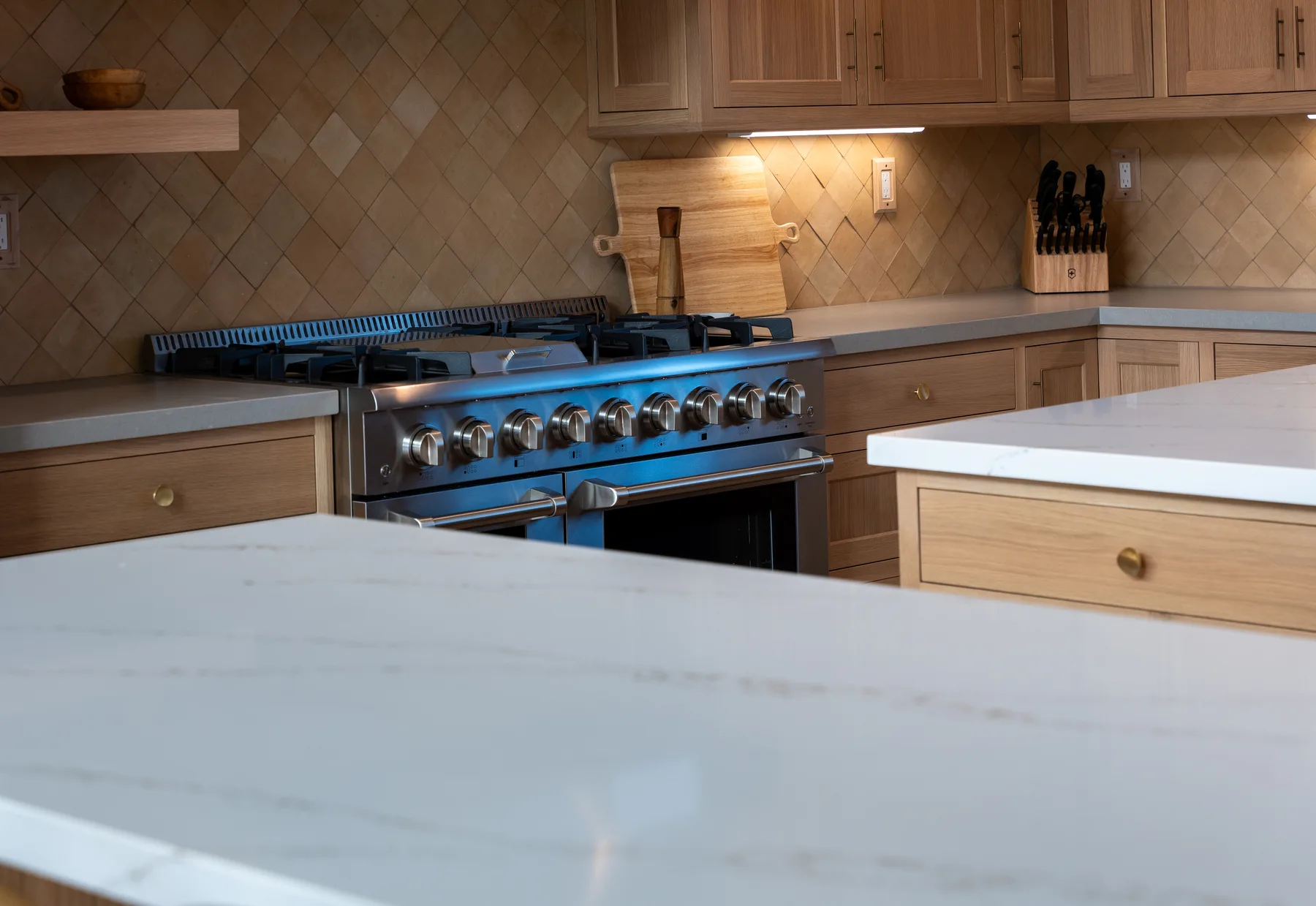 Custom kitchen cabinetry with detailed range wall and integrated lighting