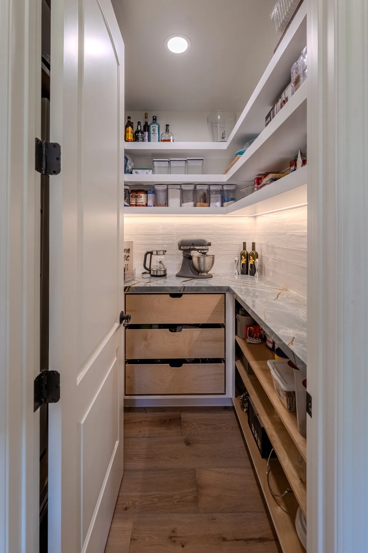 Walk-in pantry with custom shelves and counter workspace