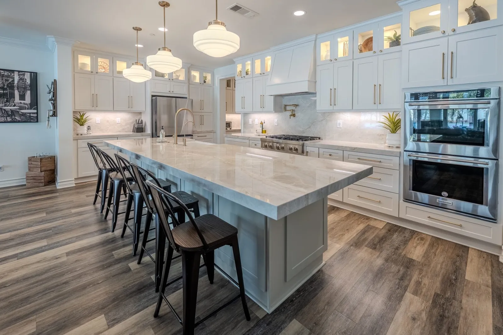 Large white kitchen with oversized stone island and cabinet storage