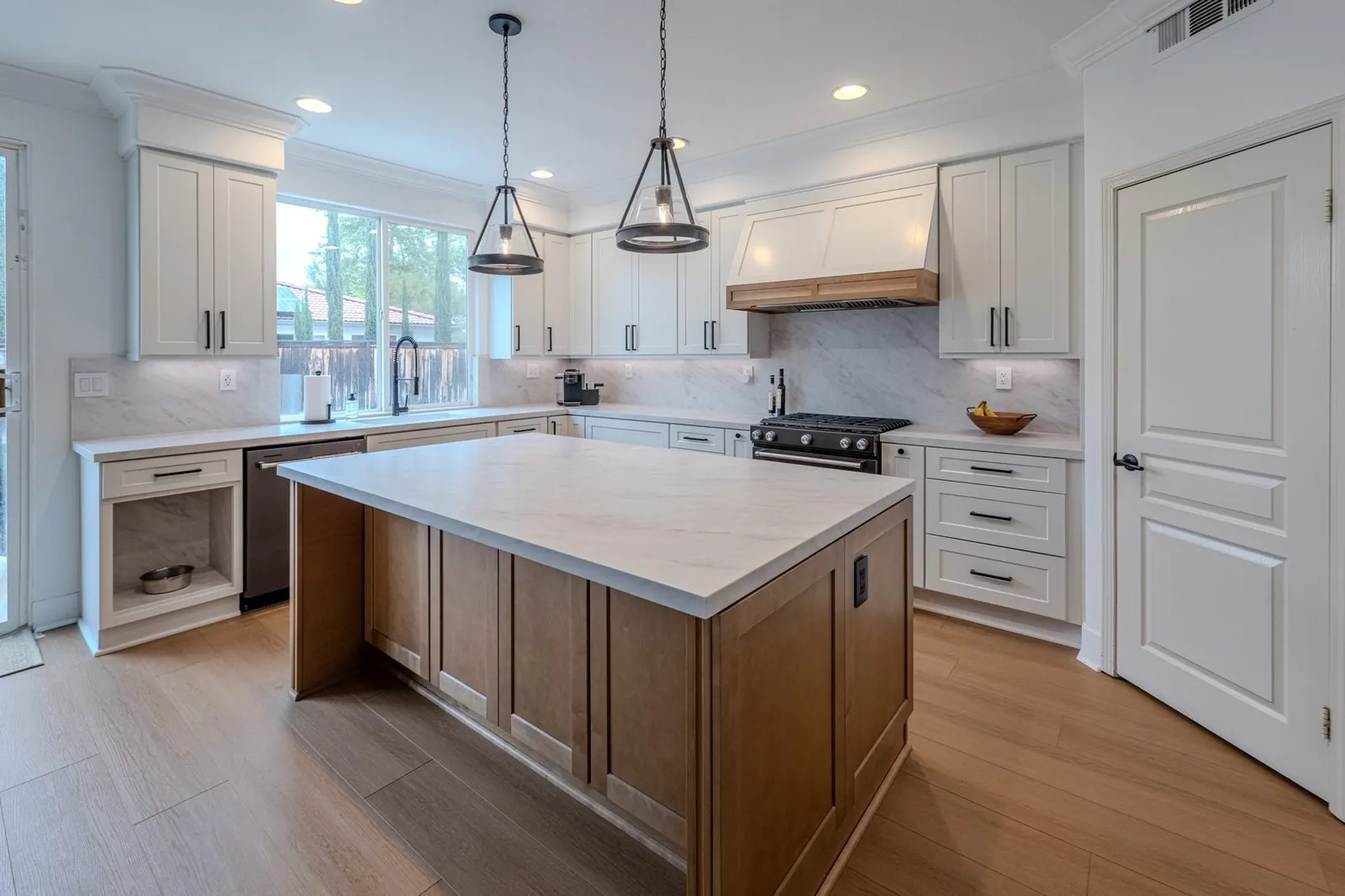 White shaker kitchen with oak island and quartz countertops