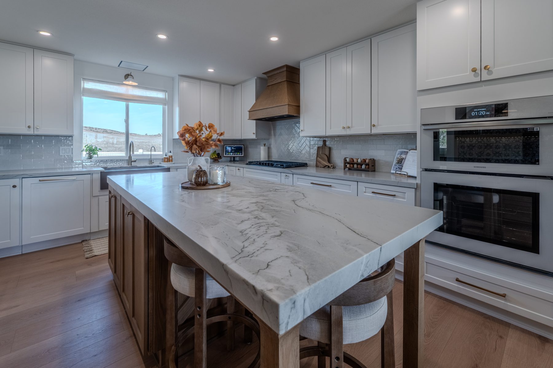 Natural stone island with mitered edge in a white and oak kitchen