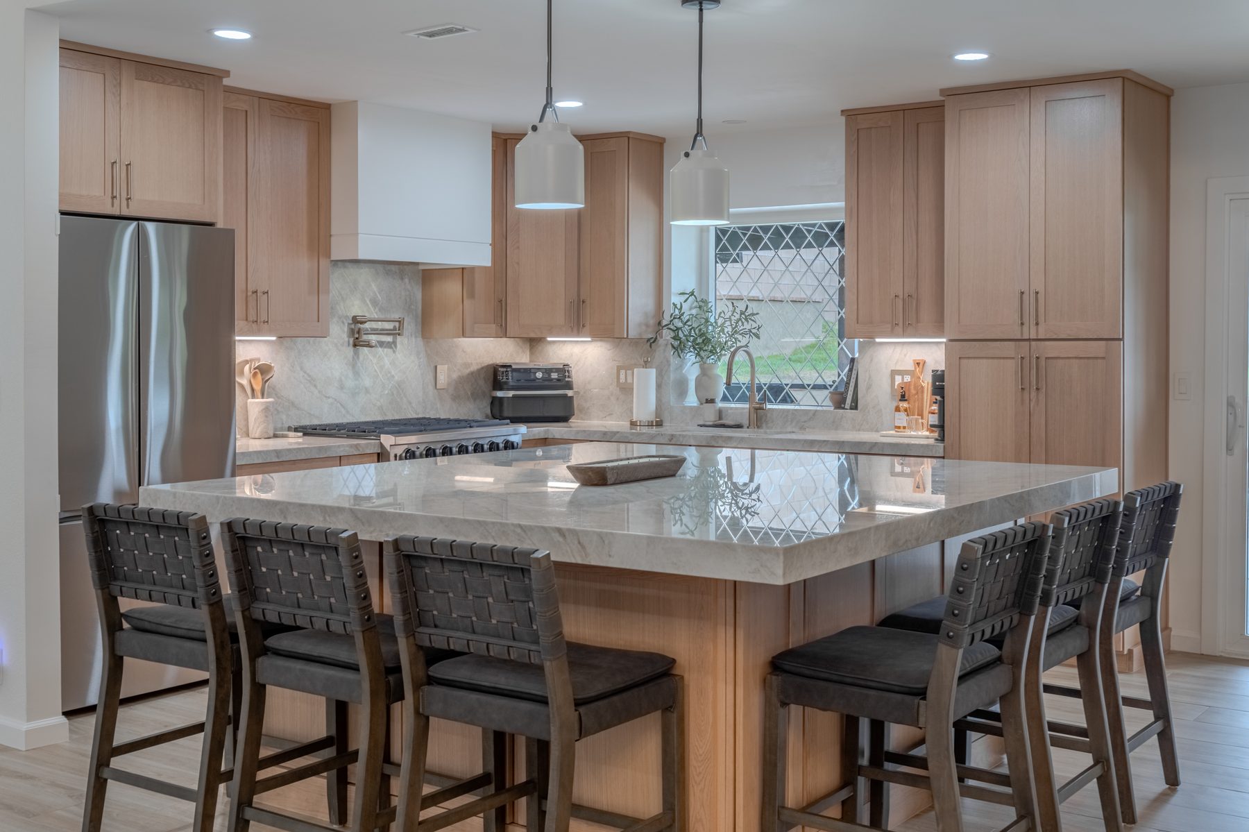 Large natural stone island paired with oak shaker cabinetry