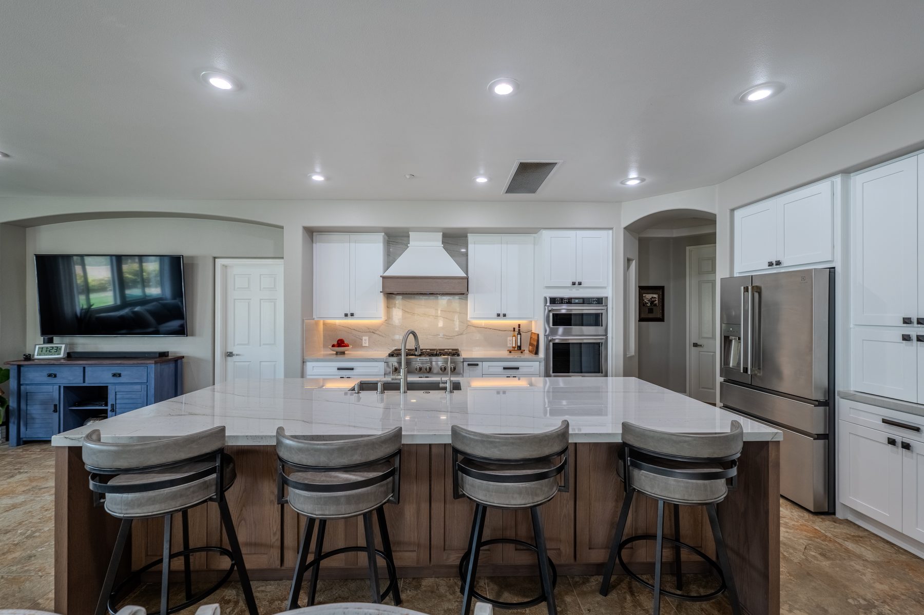 White quartz countertops and island with full-height backsplash
