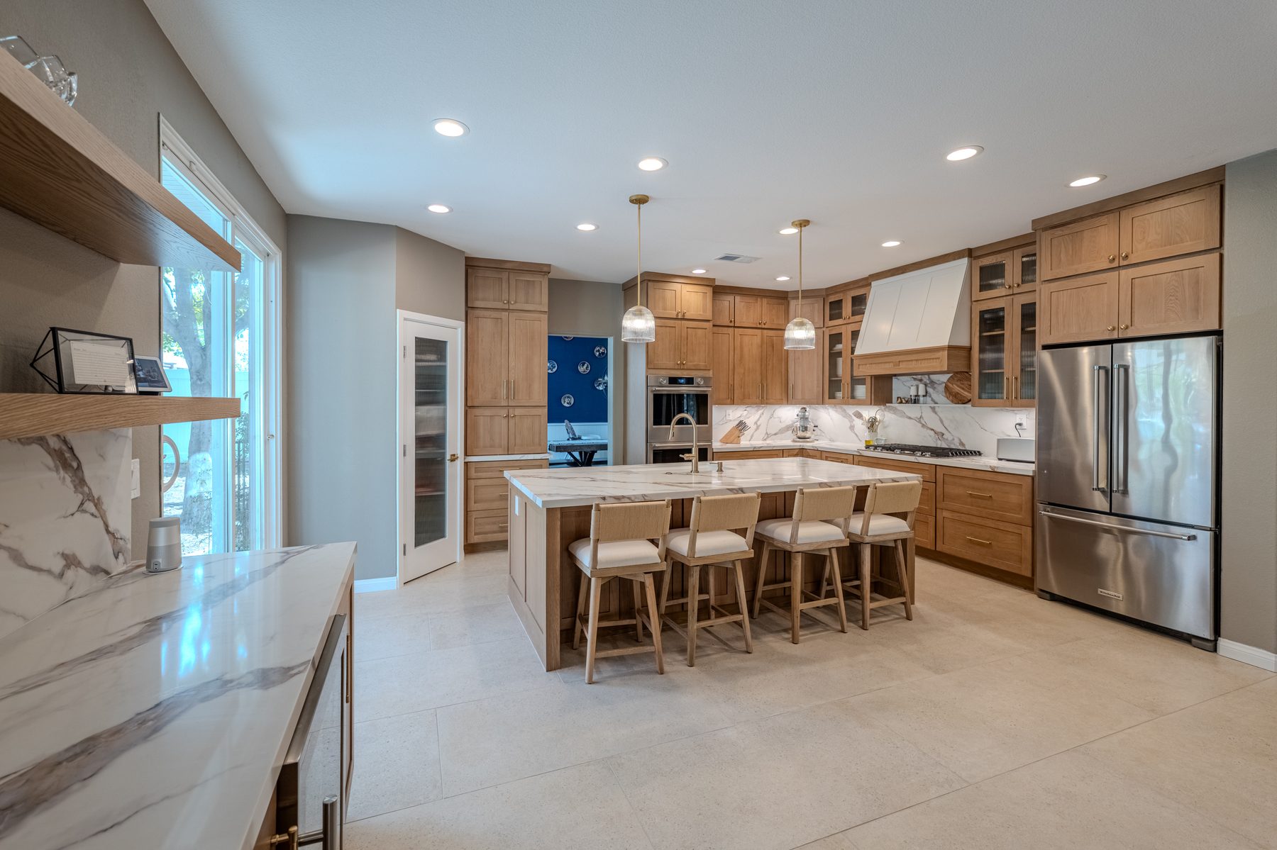 Custom oak kitchen with large island and full-height stone splash