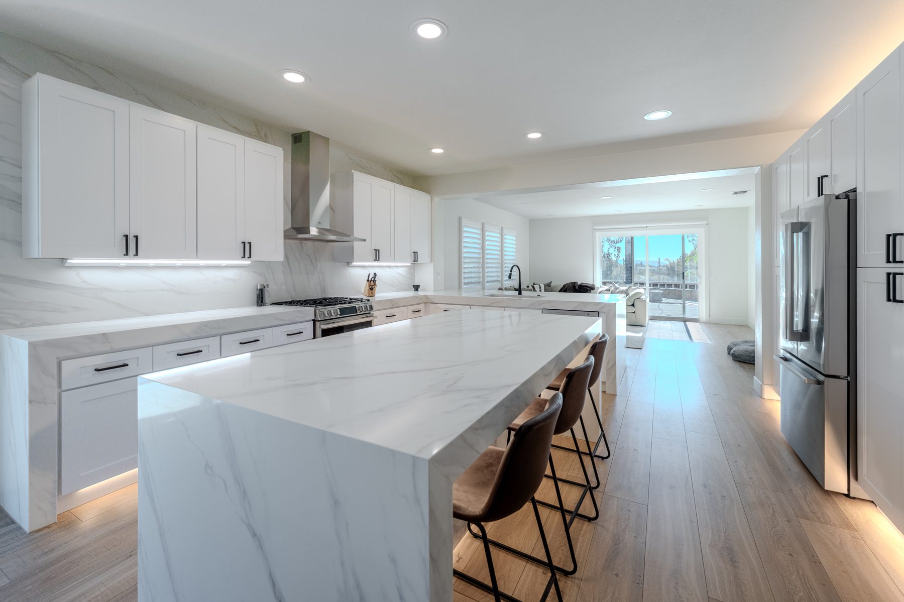 Bright white kitchen with waterfall island and integrated lighting