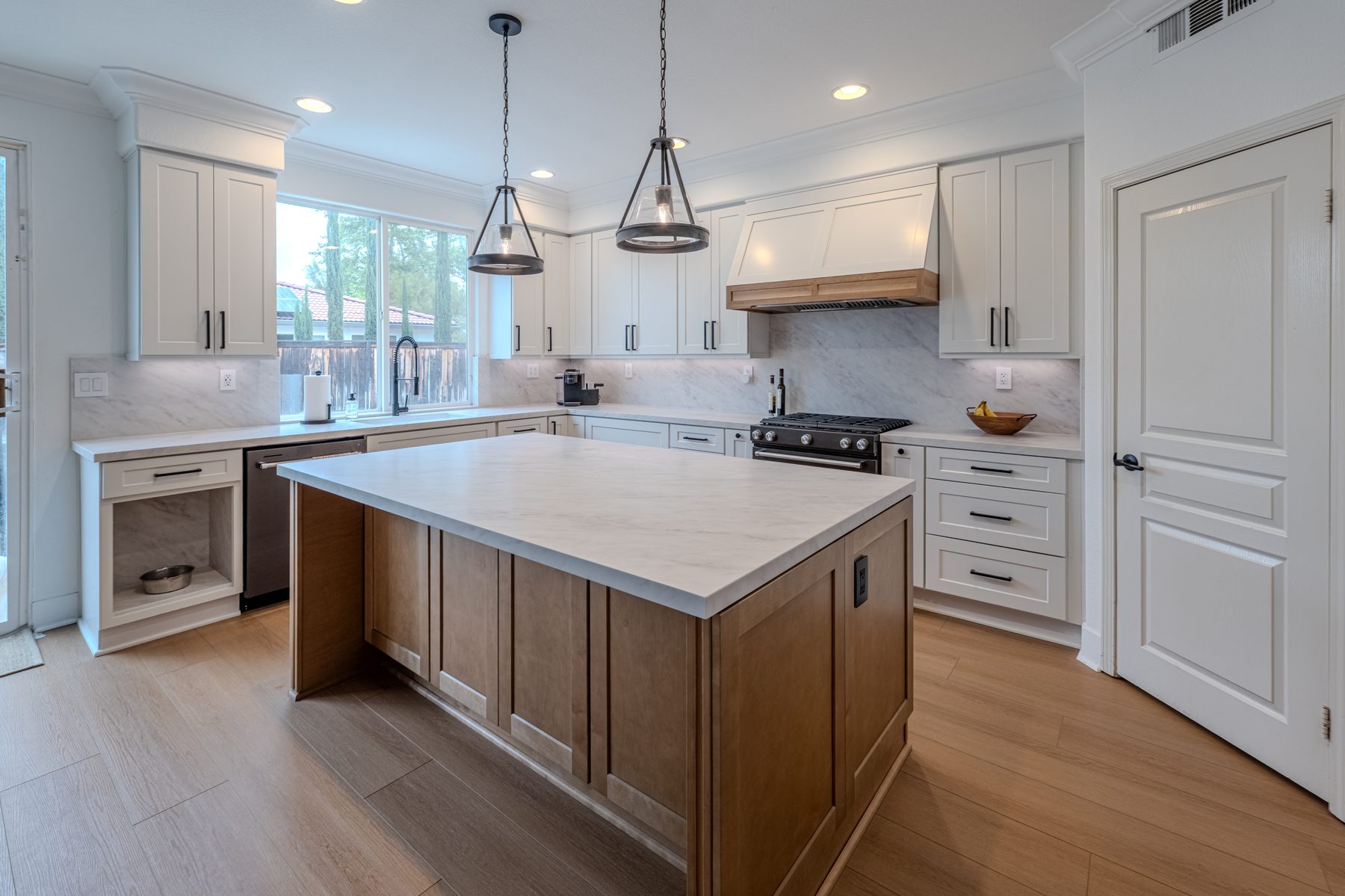 White shaker kitchen with oak island and quartz countertops